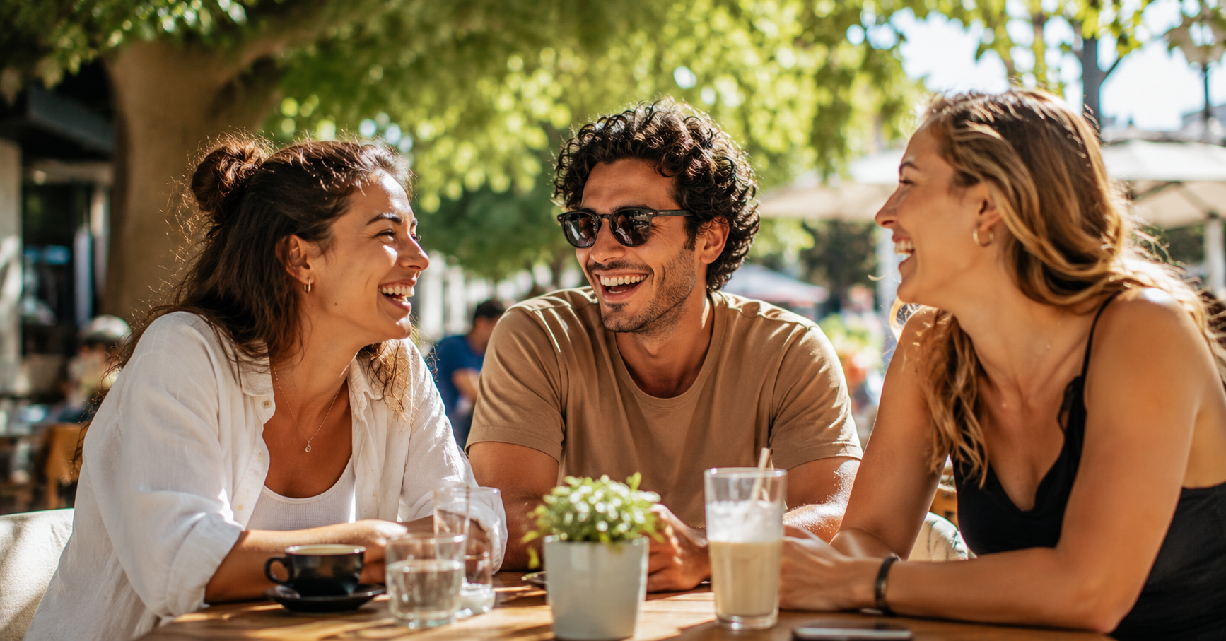 Three friends laughing at outdoor cafe
